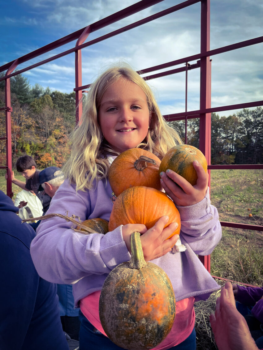 Girl with pumpkins on hayride